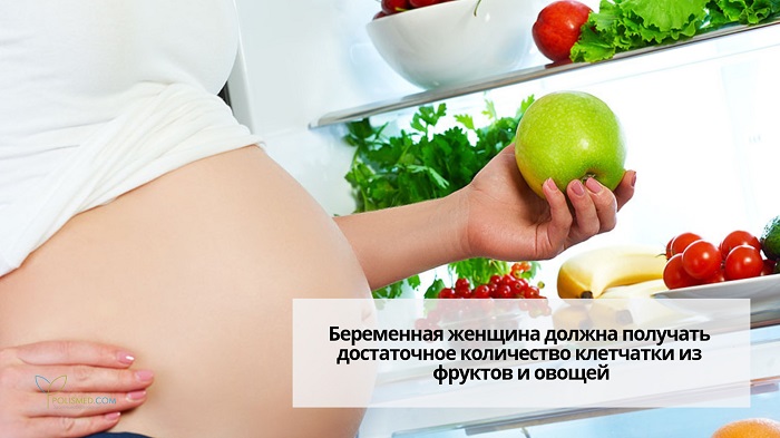 Беременная держит яблоко