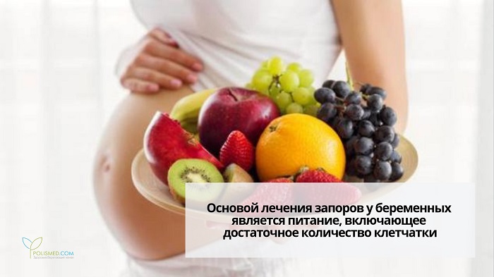 Беременная держит блюдо с фруктами